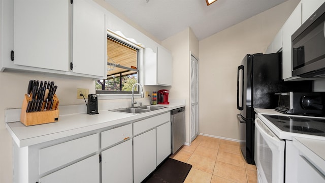 kitchen featuring white cabinets, light tile patterned floors, sink, and appliances with stainless steel finishes