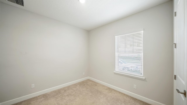 unfurnished room featuring light carpet