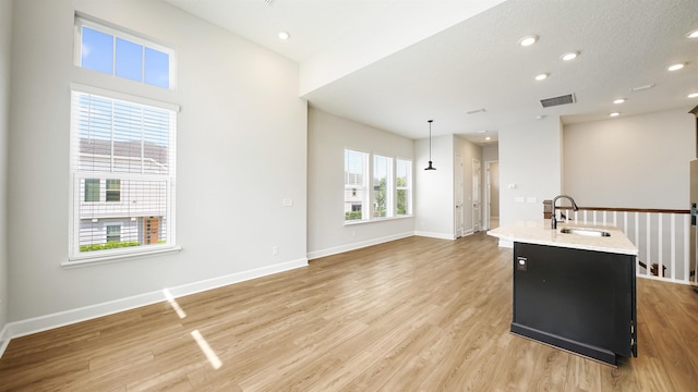 interior space featuring a textured ceiling, light wood-type flooring, and sink