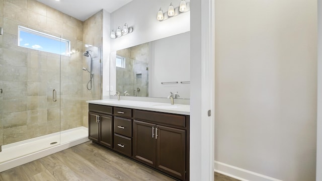 bathroom featuring wood-type flooring, vanity, and walk in shower