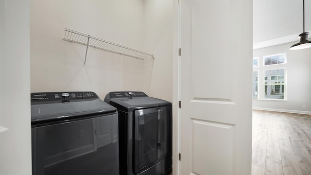 laundry area with hardwood / wood-style floors and washing machine and clothes dryer