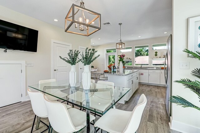 dining area featuring light hardwood / wood-style flooring and a notable chandelier