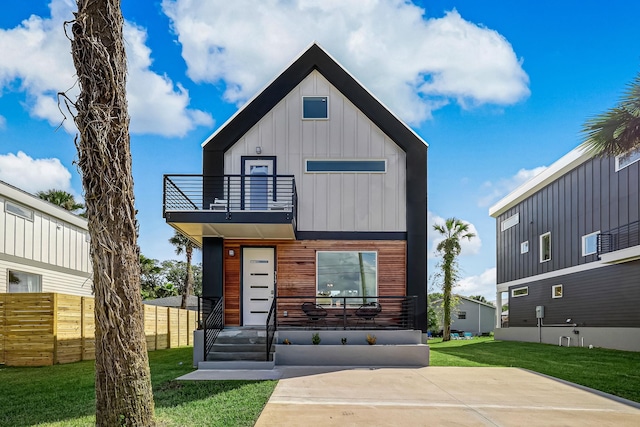 view of front of house featuring a balcony and a front yard