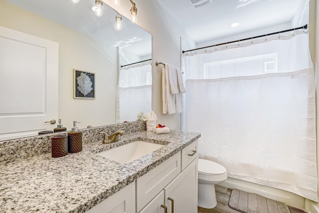 bathroom with hardwood / wood-style floors, vanity, and toilet