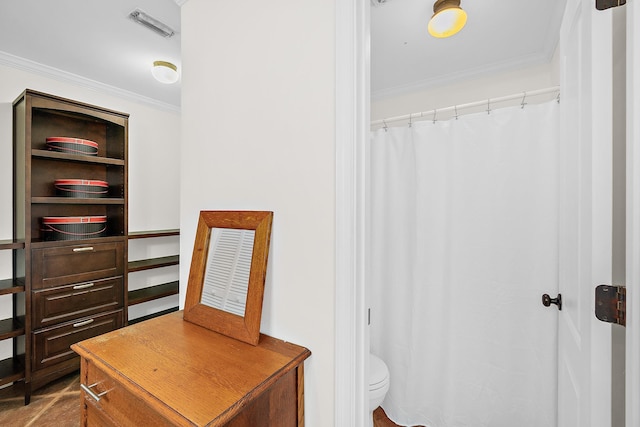 bathroom with toilet and ornamental molding