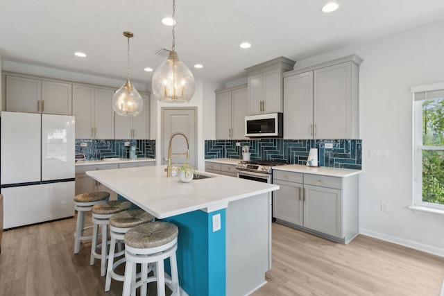 57 Guanahani Trl, Saint Augustine, FL 32080 - kitchen featuring freestanding refrigerator, gray cabinetry, backsplash, light wood finished floors, and recessed lighting