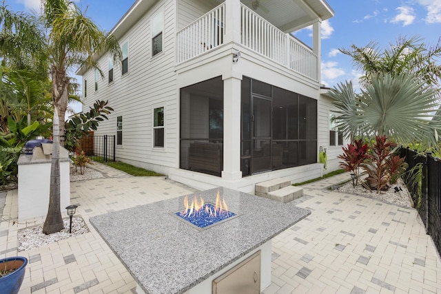 57 Guanahani Trl, Saint Augustine, FL 32080 - back of house with a balcony, a sunroom, a patio, and a fire pit