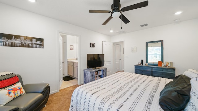 bedroom with light carpet, connected bathroom, and ceiling fan