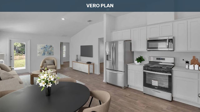 kitchen with white cabinets, light wood-type flooring, stainless steel appliances, and vaulted ceiling