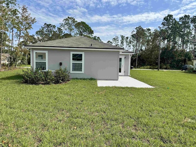 back of property with a patio area and a yard