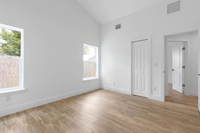 441 S Woodlawn St, Saint Augustine, FL 32084 - unfurnished bedroom with multiple windows, light wood-style floors, high vaulted ceiling, and a closet