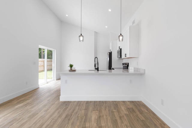 441 S Woodlawn St, Saint Augustine, FL 32084 - kitchen with appliances with stainless steel finishes, a peninsula, white cabinets, light countertops, and high vaulted ceiling