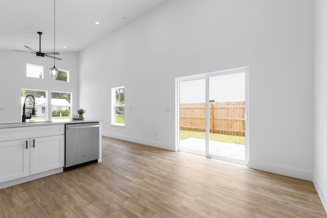 441 S Woodlawn St, Saint Augustine, FL 32084 - kitchen with dishwasher, white cabinets, a ceiling fan, a towering ceiling, and hanging light fixtures