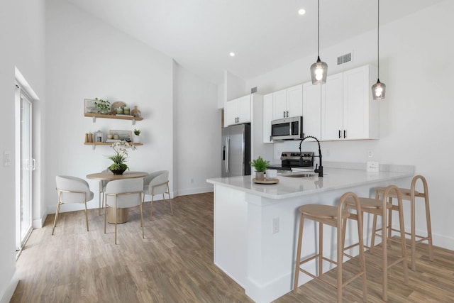 441 S Woodlawn St, Saint Augustine, FL 32084 - kitchen with appliances with stainless steel finishes, a kitchen breakfast bar, light countertops, white cabinetry, and a peninsula
