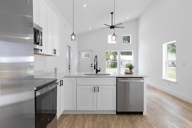 441 S Woodlawn St, Saint Augustine, FL 32084 - kitchen featuring appliances with stainless steel finishes, a peninsula, white cabinetry, light wood-type flooring, and light countertops