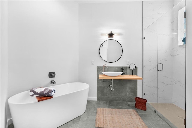 full bathroom with a freestanding tub, finished concrete flooring, a marble finish shower, and vanity