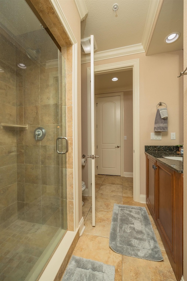 bathroom featuring vanity, toilet, ornamental molding, a textured ceiling, and an enclosed shower