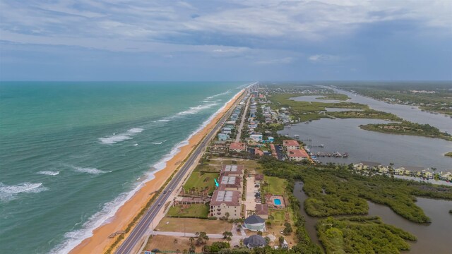 birds eye view of property with a water view and a view of the beach