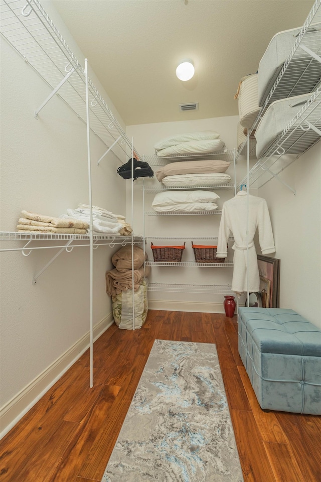 spacious closet featuring dark hardwood / wood-style flooring