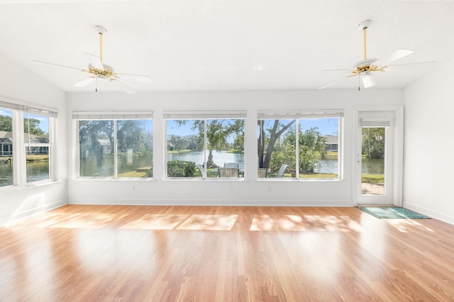 unfurnished sunroom with a wealth of natural light, a ceiling fan, and vaulted ceiling