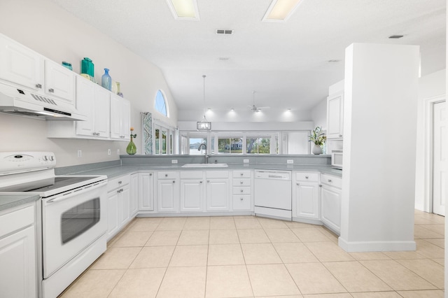 kitchen with vaulted ceiling, a sink, under cabinet range hood, white appliances, and white cabinetry