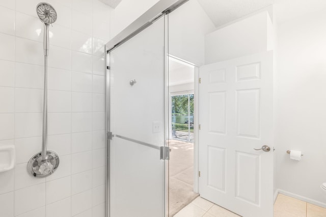 full bathroom featuring a shower stall and tile patterned flooring