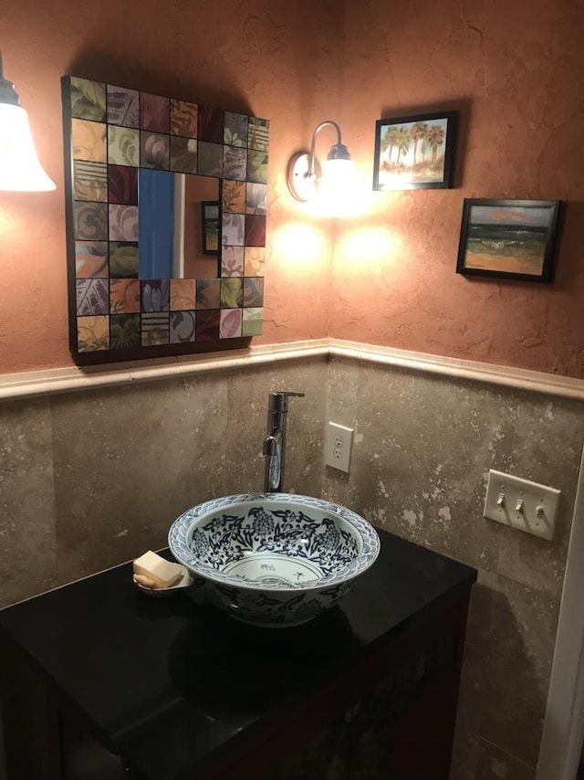 bathroom featuring sink and tile walls