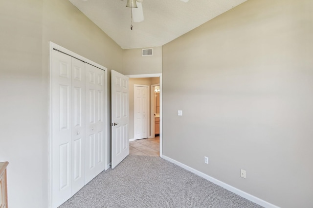 unfurnished bedroom featuring visible vents, baseboards, light carpet, a closet, and a ceiling fan