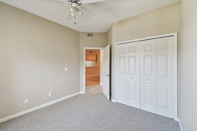 unfurnished bedroom featuring visible vents, baseboards, carpet flooring, a closet, and a ceiling fan