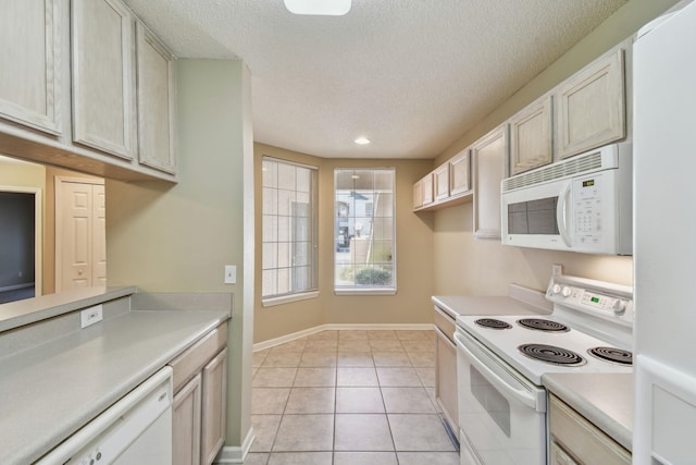 kitchen featuring a textured ceiling, white appliances, light countertops, light tile patterned floors, and baseboards