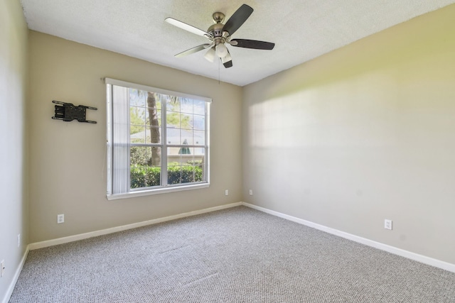 carpeted empty room featuring baseboards, a textured ceiling, and ceiling fan