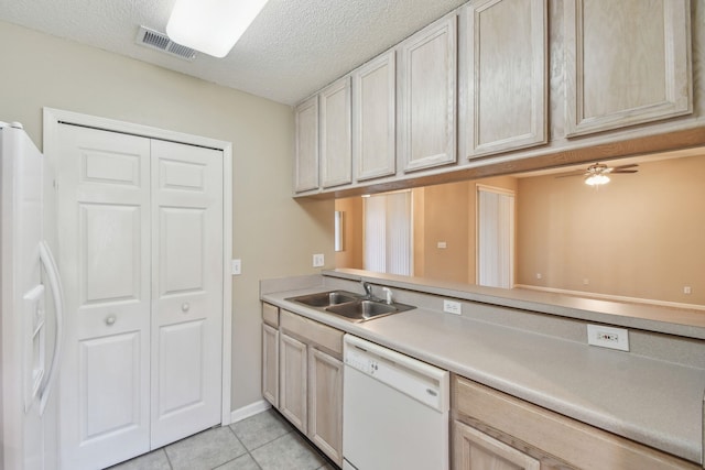 kitchen featuring visible vents, light countertops, light tile patterned flooring, white appliances, and a sink