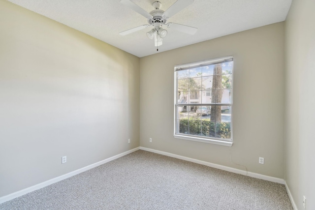 empty room featuring carpet flooring, ceiling fan, a textured ceiling, and baseboards