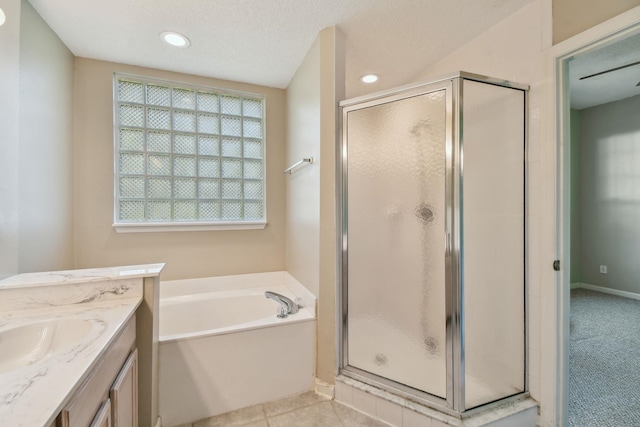 bathroom featuring tile patterned flooring, a shower stall, vanity, a garden tub, and a textured ceiling