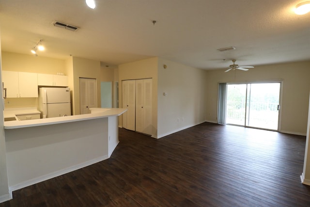 kitchen featuring white cabinetry, white refrigerator, ceiling fan, kitchen peninsula, and dark wood-type flooring