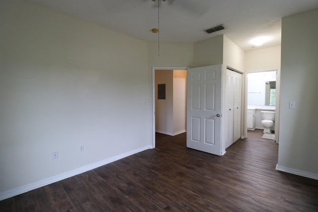 unfurnished bedroom with ceiling fan, electric panel, dark hardwood / wood-style flooring, and a closet