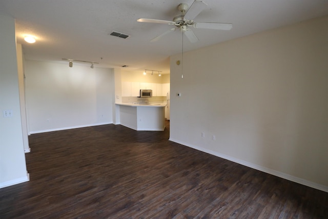 unfurnished room with dark hardwood / wood-style flooring, track lighting, and ceiling fan