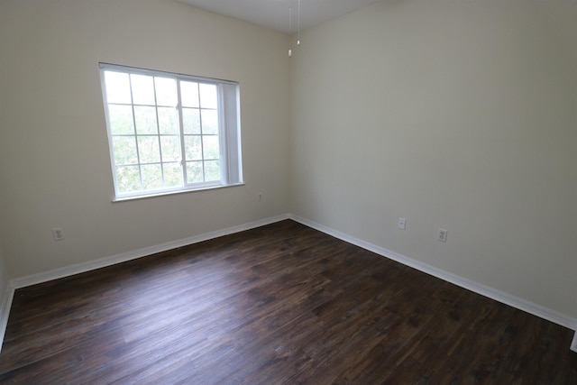 unfurnished room with dark hardwood / wood-style flooring