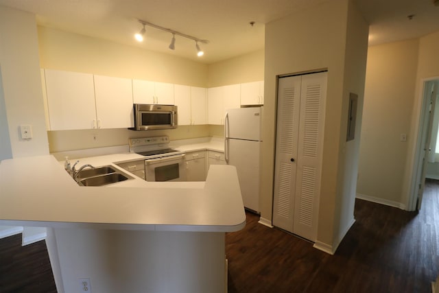 kitchen featuring sink, white appliances, dark hardwood / wood-style floors, white cabinets, and kitchen peninsula