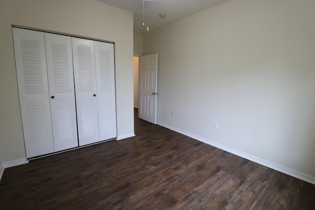 unfurnished bedroom with a closet and dark hardwood / wood-style floors