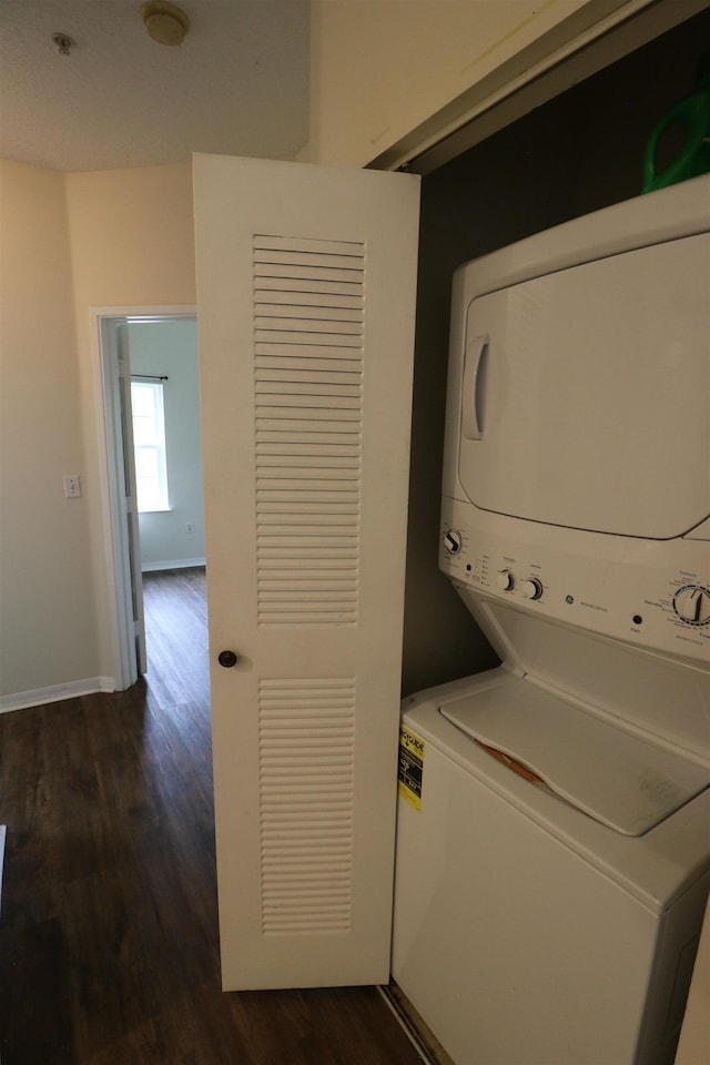 clothes washing area featuring dark hardwood / wood-style flooring and stacked washer and dryer