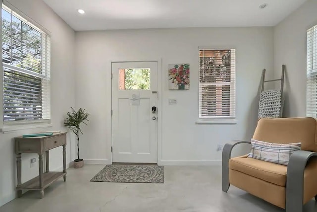 entrance foyer featuring recessed lighting, baseboards, and finished concrete floors