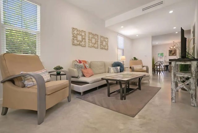 living area featuring recessed lighting, finished concrete floors, plenty of natural light, and visible vents