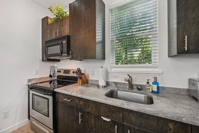 kitchen with a sink, dark brown cabinets, black microwave, and stainless steel range with electric cooktop