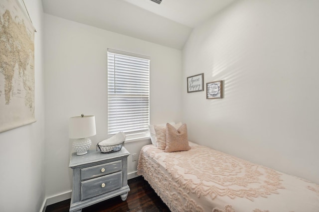 bedroom with dark wood finished floors, lofted ceiling, and baseboards