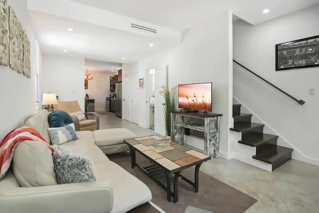 living area with stairway, recessed lighting, and concrete flooring