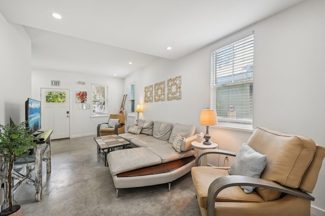 living room with recessed lighting, baseboards, and concrete flooring