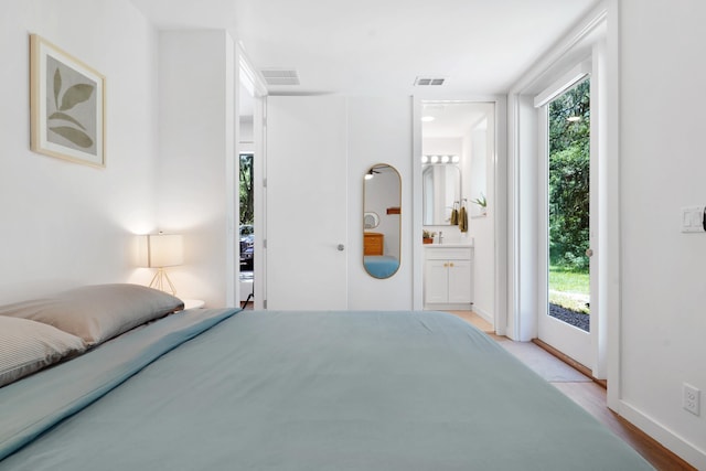 2470 Oleander St, Saint Augustine, FL 32080 - bedroom featuring multiple windows, access to exterior, wood finished floors, and ensuite bath