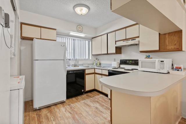 kitchen with kitchen peninsula, light wood-type flooring, white appliances, and a textured ceiling