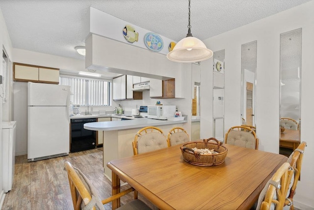 dining area with light hardwood / wood-style floors and a textured ceiling